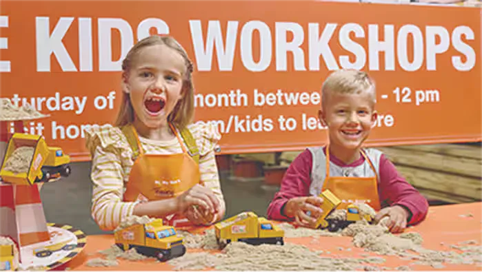 Kids building Home Depot Kids Workshop dump trucks