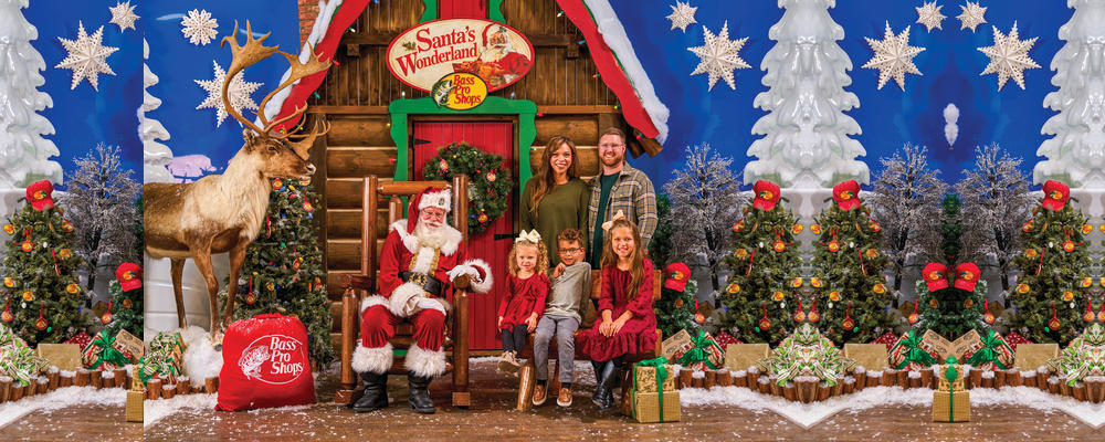 Santa and a family pose in the Bass Pro Shops Santa's Wonderland holiday set