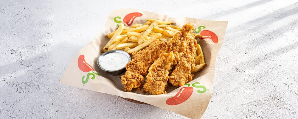 Chicken tenders and French fries with a cup of ranch dip on Chili's paper