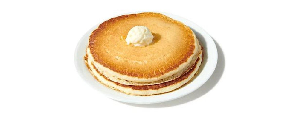 Denny’s official Stack of Pancakes: two plain buttermilk pancakes with butter on a white plate.