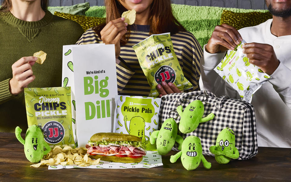 Official Jimmy John's campaign photo showing all five Pickle Pals plush keychains, a Picklewich, pickle chips and packaging
