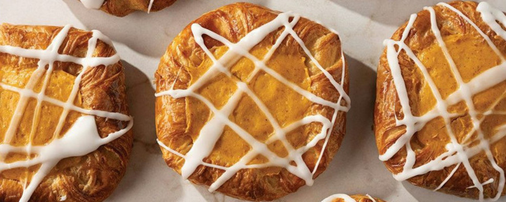 Iced golden pastries arranged on a white surface