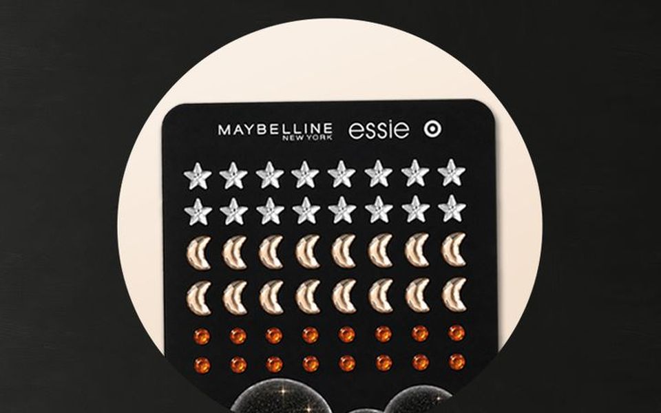 A Maybelline x essie sheet of silver star, gold moon and orange gem face stickers